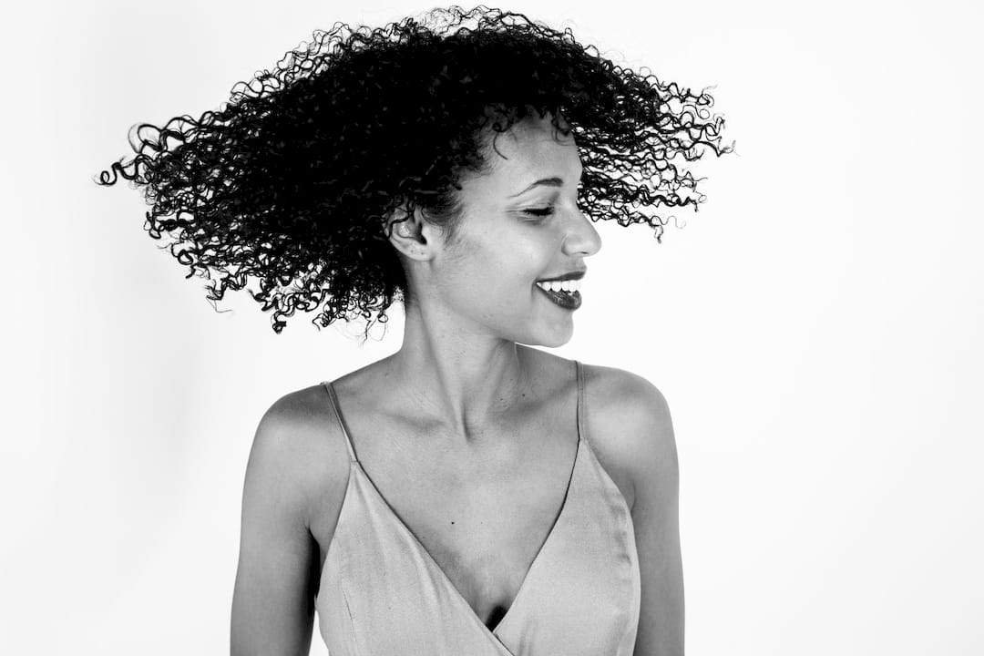 Woman applying sulfate-free shampoo to textured hair