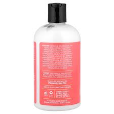 A clear plastic bottle of hair care product with a black cap and a pink label, shown against a white background.